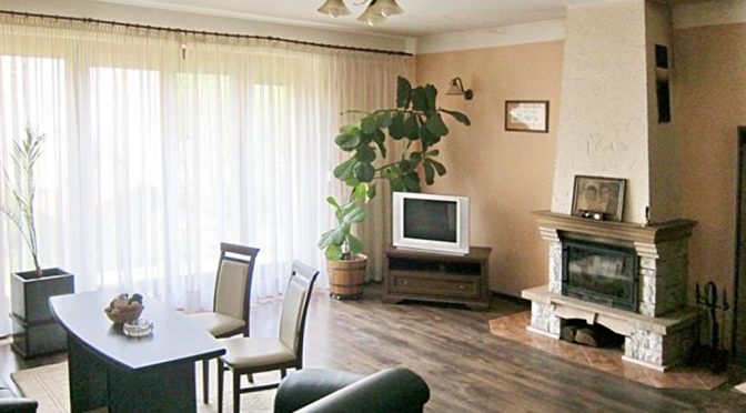 na zdjęciu salon z kominkiem w ekskluzywnej rezydencji do sprzedaży we Wrocławiu