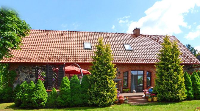 zdjęcie prezentuje front ekskluzywnej rezydencji do sprzedaży na Mazurach