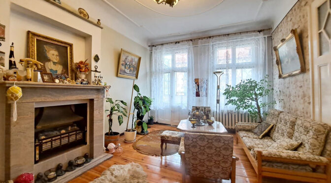 na pierwszym planie efektowny kominek w salonie luksusowego apartamentu na sprzedaż Legnica