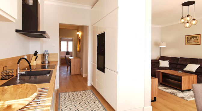 po lewej aneks kuchenny, po prawej salon w luksusowym apartamencie do wynajęcia Słupsk